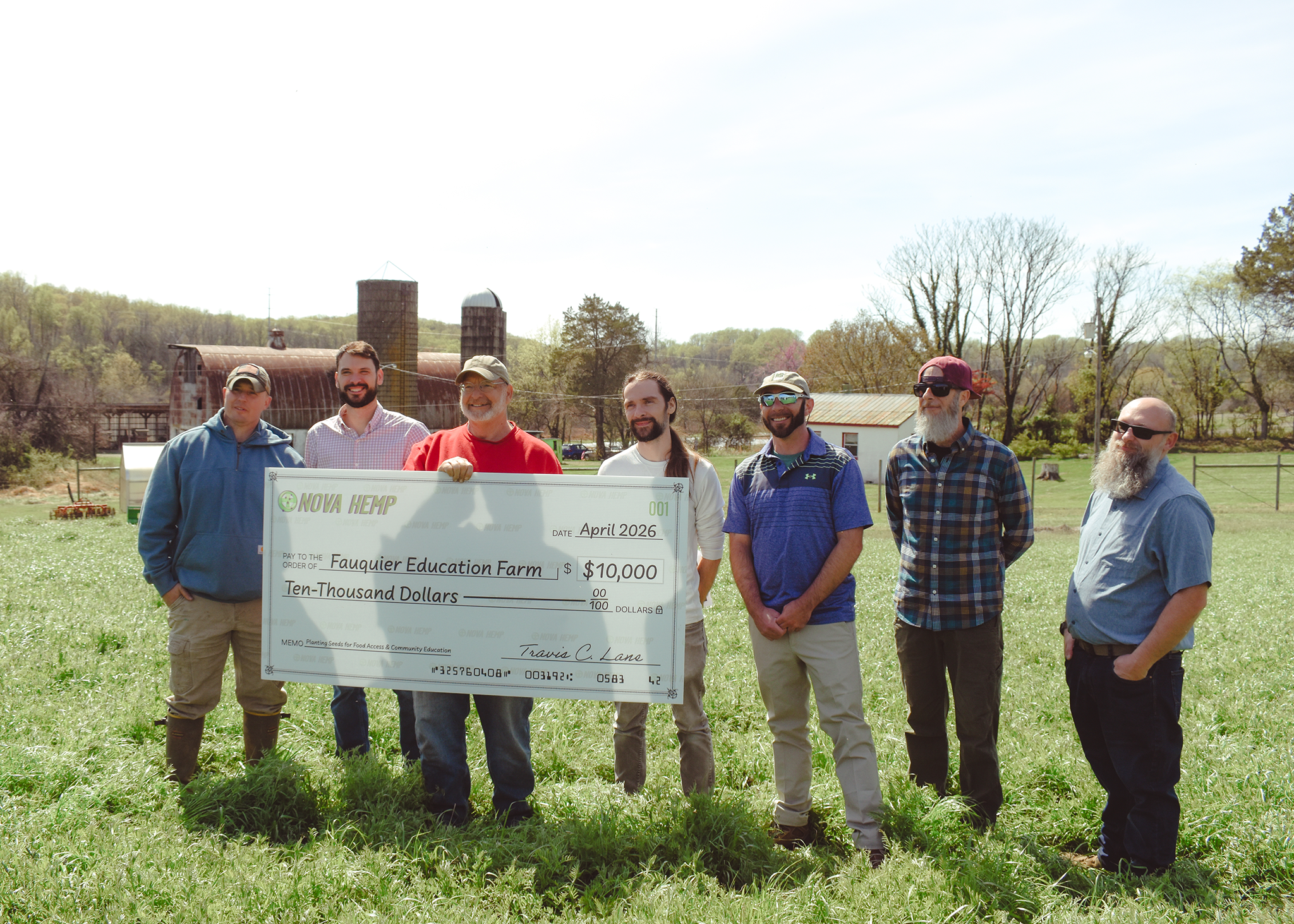 A group of seven people holding a large check for $10,000 at Fauquier Education Farm.